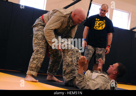 Staff Sgt. Eugene Patton (top), Colorado Army National Guard, grapples with Staff Sgt. Brian Bower, Arizona Army National Guard, during their combatives bout in the 2012 Region VII Best Warrior Competition at Camp San Luis Obispo, Calif., April 25. The combatives event challenged competitors to submit their opponent within six minutes using an authorized hold, or win by majority of points gained throughout the match using various moves. (Army National Guard photo/Spc. Grant Larson) The best warriors in Region VII clash to earn the right to compete at Nationals 120425-A-PP889-534 Stock Photo
