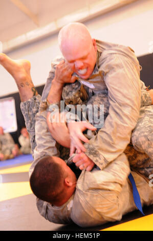 Staff Sgt. Eugene Patton (top), an intelligence analyst with Colorado Army National Guard 117th Space Battalion, grapples with his opponent Staff Sgt. Brian Bower, a combat engineer with Arizona Army National Guard 819th Sapper Company, during their combatives bout in the 2012 Region VII Best Warrior Competition at Camp San Luis Obispo, Calif., April 25. Slightly noticeable in this photo, Patton suffered a bloody nose, resulting in a short pause in the match. The combatives event challenged competitors to submit their opponent within six minutes using an authorized hold, or win by majority of  Stock Photo