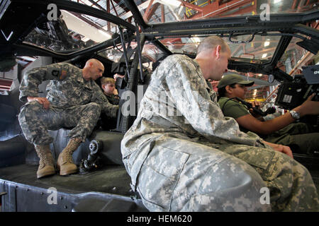 (from left) Chief Warrant Officer Frank Capri and Capt. Joseph Sinkiewicz, pilots assigned to B Company, 1st Battalion, 10th Combat Aviation Brigade, show a pair of Boy Scouts the cockpit of the Apache helicopter at Wheeler-Sack Airfield, May 12. The Boy Scouts were visiting for the weekend to get a taste of Army life and celebrate the values shared by the Boy Scouts and America's military. 1-89 CAV hosts Boy Scout visit to Fort Drum 051212-A-EB125-066 Stock Photo