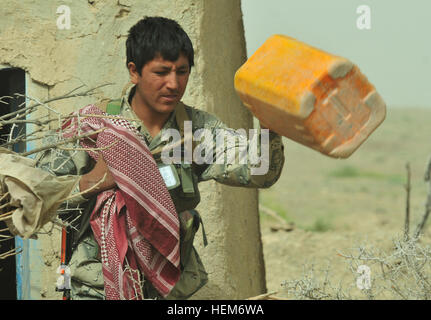 An Afghan Border Policeman pulls out an empty jug that he found while searching abandoned houses for contraband during Operation Southern Strike II in southern Afghanistan, June 6, 2012. Yellow jugs are often used as a container for homemade explosives by terrorists in Afghanistan. ABP lead successful operation in southern Afghanistan 120606-A-DL064-424 Stock Photo