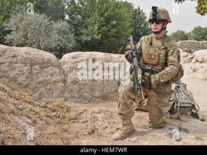 U.S. Army Pfc. John Quinton, a native of Social Circle, Ga., and grenadier assigned to 3rd Platoon, A Battery, 2nd Battalion (Airborne), 377th Parachute Field Artillery Regiment, pulls security outside of a female school in the village of Mangas July 7, 2012. Paratroopers of Task Force 2-377 pulled security in and around the school while members of the female engagement team spoke with teachers of the school to discuss concerns about the schools future. A Battery, PFAR facilitates FET mission 620306 Stock Photo