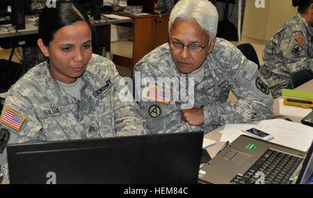 Sgt. Chalce Silva and Master Sgt. Virgine Kanoa with the 29th Brigade Support Battalion, Hawaii Army National Guard, work on a computer simulation designed for training throughout exercise Tiger Balm, July 16. Soldiers from Oregon, Hawaii and Washington train with the Singapore armed forces during this two week bi-lateral exercise held in Waimanalo, Hawaii. Members from the 29th Brigade Support work on computer simulations 120716-A-VA705-012 Stock Photo