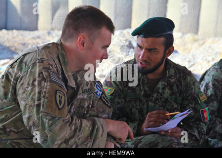 U.S. Army Staff Sgt. Tylerscott Rumely, with the 737th Explosive Ordinance Disposal Company, teaches an Afghan National Army soldier how to fill out a five-line unexploded ordnance report during a blow in place/sweep training course at Camp Maiwand at Forward Operating Base Shank in Logar province, Afghanistan, Sept. 10, 2012. The course covered topics such as explosives training and battle drills. (U.S. Army photo by Spc. Alexandra Campo/Released) ANA training in Logar province 120910-A-RT803-006 Stock Photo