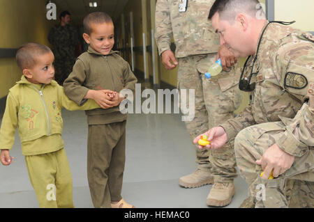 U.S. Air Force Lt. Col. John Savage, a Military Training Advisory Team mentor, hands small toys to children at Kandahar Regional Medical Hospital during women and children's day at the hospital on Camp Hero in Kandahar, Afghanistan, Sept. 25, 2012. KRMH is one of five hospitals of its kind in the country and specializes in treating Afghan National Army soldiers and Afghan police members. Inside an Afghan security forces%%%%%%%%E2%%%%%%%%80%%%%%%%%99 hospital 120925-A-YE732-021 Stock Photo