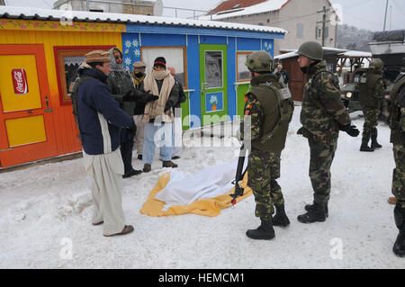 Romanian soldiers meet with civilian role-players during a military advisory team (MAT) training exercise at the Joint Multinational Readiness Center in Hohenfels, Germany, Dec. 9, 2012. MATs and police advisory team rotations are designed to replicate the Afghanistan operational environment while preparing teams for counterinsurgency and improvised explosive device operations with the ability to train, advise and enable the Afghanistan National Army and the Afghanistan National Police.  (U.S. Army photo by Spc. Wayne Becton/Not Released) Military and Police Advisory Training II at the Joint M Stock Photo