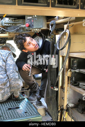 International Boy Scout Chafic Saade, 13, Direct Service Troop 965, explores a mine resistant ambush protected vehicle with the 47th Transportation Company at Camp Arifjan, Kuwait, Saturday, Jan. 12, 2013. Soldiers of the 47th, deployed from Fort Bliss, Texas, gave the Scouts a tour of the vehicles and explained their features. (U.S. Army photo by Sgt. William E. Henry, 38th Sustainment Brigade) Boy Scouts visit US soldiers in Kuwait 130112-A-TC907-003 Stock Photo