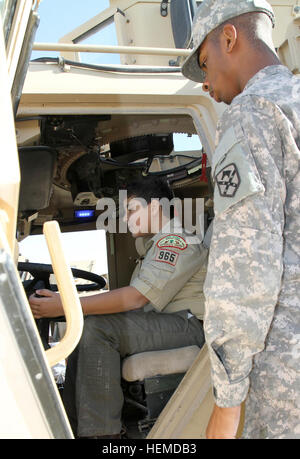 Army Pfc. De'Marcus Salter, a 47th Transportation Company motor transport operator, explains features of a resistant ambush protected vehicle to international Boy Scout Yousef Abdel-Rahman, 12, Direct Service Troop 965, at Camp Arifjan, Kuwait, Saturday, Jan. 12, 2013. Salter, from Monroeville, Ala., helped give the Scouts a tour of the vehicles and explained their features. (U.S. Army photo by Sgt. William E. Henry, 38th Sustainment Brigade) Boy Scouts visit US soldiers in Kuwait 130112-A-TC907-004 Stock Photo