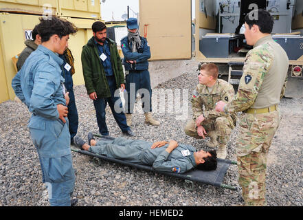 U.S. Army Sgt. Eric Thompson, a Texas Army National Guardsman with the 56th Infantry Brigade Combat Team, explains stretcher carrying techniques to Afghan National policemen during combat first aid training at Forward Operating Base Hadrian, Deh Rawud district, Uruzgan province, Afghanistan, Feb. 13, 2013. During the past two months, 21 policemen in Deh Rawud district have been trained in Combat Life Saver first aid by U.S. Army Soldiers with the 56th Infantry Brigade Combat Team Police Security Force Advisor Team and now one of the Afghan patrolmen has stepped up to train his fellow officers. Stock Photo