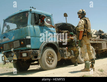 070624-A-2013C-021 An Afghan soldier searches a vehicle while a Polish soldier stands nearby at a vehicle search checkpoint on a road in Andar Distict, Ghazni Province, Afghanistan, June 24, 2007. Vehicles are searched to prevent weapons or explosives from beign smuggled across the country. (U.S. Army photo by Spc, Micah E. Clare) Polish soldier at a vehicle checkpoint in Afghanistan Stock Photo