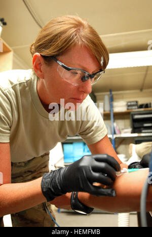 Navy Lt. Betsy Hoyos De Albers starts an intravenous line in the arm of a patient at the Role Two hospital at Multi National Base Tarin Kot, Afghanistan, on Mar. 17, 2013. Hoyos, who is stationed in Jacksonville, Fla., is an intensive care nurse. (U.S.  Army photo by Sgt. Jessi Ann McCormick) Women serving in Uruzgan province, Afghanistan 130317-A-FS372-754 Stock Photo