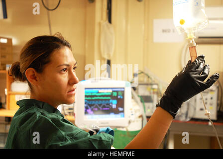 Navy Lt. j.g. Johanna Bermudez-Vera checks the drip on a fluid bag for an intravenous line at the Role Two hospital at Multi National Base Tarin Kot, Afghanistan, on Mar. 17, 2013. Bermudez-Vera, a Colombia native, is a registered nurse. (U.S.  Army photo by Sgt. Jessi Ann McCormick) Women serving in Uruzgan province, Afghanistan 130317-A-FS372-759 Stock Photo