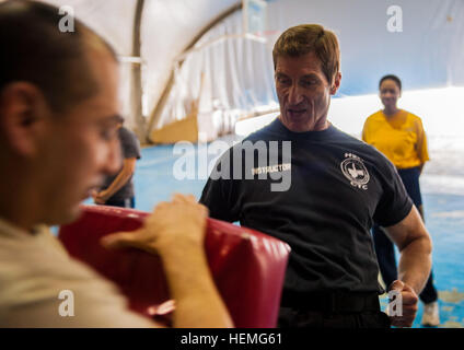 Michael Foley demonstrates the proper striking technique during a self-defense class for women March 31, 2013, Bagram Air Field, Afghanistan. (Army photo by Sgt. Joshua S. Edwards/ 129th Mobile Public Affairs Detachment) Retired service member teaches self defense in Afghanistan 130331-A-GZ125-008 Stock Photo