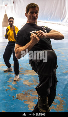 Michael Foley demonstrates the proper striking technique during a self-defense class for women March 31, 2013, Bagram Airfield, Afghanistan. (Army photo by Sgt. Joshua S. Edwards/ 129th Mobile Public Affairs Detachment) Retired service member teaches self defense in Afghanistan 130331-A-GZ125-009 Stock Photo