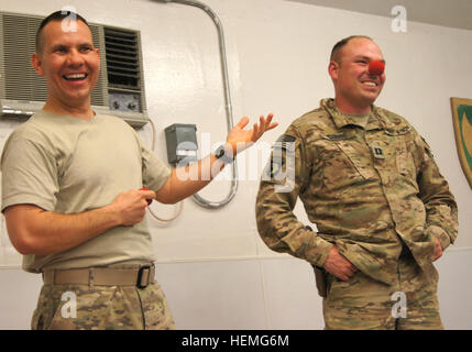 U.S. Army Capt. John Morris plays along with a joke by Maj. Bruce Townley, a native of Chamois, Mo., at Forward Operating Base Lightning March 31, 2013. Morris and Townley are advisers to the Afghan National Army's 203rd 'Thunder' Corps in the Paktya province of Afghanistan. Townley, an alumnus of Ringling Brothers and Barnum & Bailey Clown College, performed an Easter Sunday magic and juggling show for the soldiers of FOB Lightning. (U.S. Army photo by Spc. Ryan Scott, 129th Mobile Public Affairs Detachment/RELEASED) Army major clowns around at FOB Lightning 130331-A-HL120-002 Stock Photo