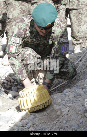 An Afghan National Army soldier demonstrates attaching a pulley system to a simulated improvised explosive device (IED) during a counter IED course on Forward Operating Base Shank, Logar province, Afghanistan, April 1, 2013. The counter IED course offers in-depth information and hands-on training through an interactive environment with various examples of IEDs. (U.S. Army photo by Sgt. Thomas Childs/Released) ANA counter-IED training 130401-A-WF228-022 Stock Photo