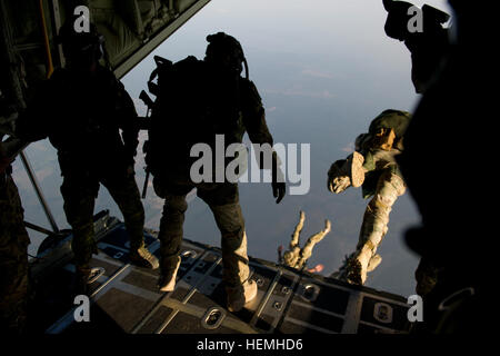 Special operations jumpers from the Canadian Special Operations Regiment, Green Berets of 7th Special Forces Group (Airborne) and Para-rescue airmen from the Air Force Special Operations Command begin exiting a British C-130 from the Royal Air Force during a high altitude low opening parachute jump (HALO) Hurlburt Field, Fla., April. 25, 2013. Special operations members from coalition forces participated in HALO jumps during Exercise Emerald Warrior, Emerald Warrior is an exercise designed to provide irregular training at the tactical and operational levels. The exercise involved all branches  Stock Photo