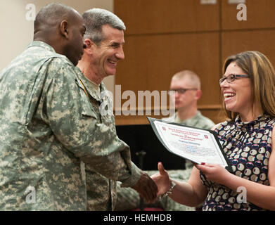 Marissa Wentling receives a certificate of appreciation from 82nd Airborne Division Commander Maj. Gen. John W. Nicholson Jr. and Command Sgt. Maj. LaMarquis Knowles during the division's volunteer recognition ceremony, April 25. Marissa, her husband, Spc. Matthew Wentling, 3rd General Support Aviation Battalion, 82nd Combat Aviation Brigade, and their two children, Marisol and Kaleb, were named the first runner up, 2013 Association of the United States Army Volunteer Family of the Year. 'Time is precious and we recognize that it takes our volunteers to help take care of our families,' said Lt Stock Photo