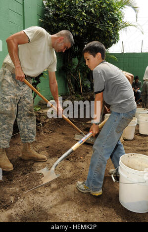 Caleb MacLean (right), a Boy Scout with Troop 967 in San Salvador, works alongside U.S. Army Sgt. 1st Class Joseph Infante, 136th Engineer Company, Maine Army National Guard, as they lay the groundwork for improvements being done during Beyond the Horizon (BTH) at the Mi Casa Orphanage at Santa Tecla, El Salvador, June 1, 2013. The project will help MacLean reach his goals to become an Eagle Scout. BTH is a chairman of the Joint Chiefs of Staff-directed, U.S. Southern Command-sponsored joint and combined field training humanitarian exercise.  (U.S. Army photo by Sgt. Richard Frost/Released) US Stock Photo