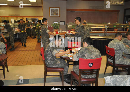 U.S. soldiers and soldiers from Third Republic of Korea Army enjoy their lunch in Thunder Inn Dining Facility during a Combined Counterfire Exercise on Camp Casey July 18, 2013. The simulation-based exercise is to enhance the ROK-U.S. counterfire capability, improve staff coordination, and test battle command systems. The 210th Fires Bde. trains with its ROK partners to strengthen the alliance and ensure it is ready to 'Fight Tonight' to deter any threats toward the Republic of Korea. (U.S. Army photo by Cpl. Kim Han-byeol, 210th Fires Brigade public affairs specialist/Released). ROK-US Combin Stock Photo