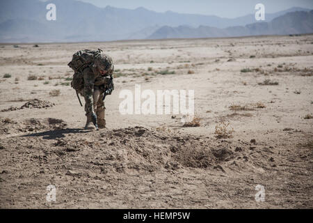 U. S. Army Staff Sgt. Douglas Firely with 4th Infantry Brigade Combat Team, 3rd Infantry Division, 6th Squadron, 8th Cavalry Regiment, (6-8 Cav) Alpha Troop, 1st Platoon uses a knife to check the ground at the explosion site near Panagazeen village, Afghanistan, Aug. 23, 2013. U.S. Soldiers with 1st Platoon patrolled the area to engage the local populace and conduct counter indirect fire. (U.S. Army photo by Spc. Amber Stephens/Released) Logar patrol 130823-A-YX345-097 Stock Photo