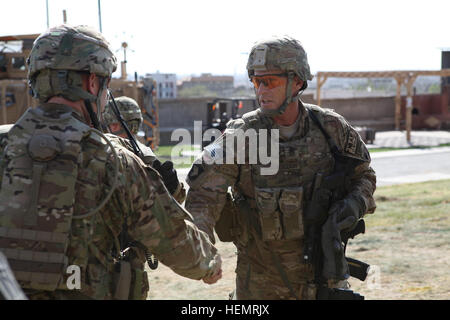 U.S. Army Lt. Col. Mark Huhtanen, left, deputy brigade commander 2nd Brigade Combat Team, 1st Cavalry Division, greets Command Sgt. Maj. Scott Schroeder at the U.S. Consulate Herat, Herat province, Afghanistan, Sept. 24, 2013. Command Sgt. Maj. is the leading enlisted personnel for the International Security Assistance Force (ISAF) International Joint Commission (IJC) and Army 3rd Corps. (U.S. Army photo by Spc. Ryan D. Green/Released) Delta Company, 1-5 Cavalry re-enlistment ceremony at US Consulate Herat 130924-A-YW808-008 Stock Photo