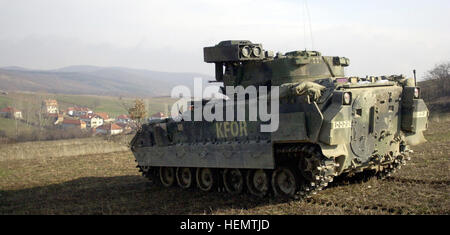 000315-A-0000K-003 An M2 Bradley Fighting Vehicle stood guard over the village of Stublina as KFOR soldiers searched the houses below.  KFOR soldiers carried out a carefully planned and orchestrated operation on Wednesday, March 15, 2000, to search and confiscate illegal weapons at five separate locations near the Serbian border.  A total of 22 crates of ammunition, hand grenades, mines, rifles, other explosivies, and chemical protective masks were found.  KFOR is the NATO-led, international military force in Kosovo on the peacekeeping mission known as Operation Joint Guardian. Defense.gov New Stock Photo