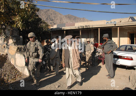 Soldiers from 3rd platoon, Destined Company, 2nd Battalion (Airborne), 503rd Infantry Regiment, 'The Rock,' finish their meeting with the Narang sub-governor before delivering school supplies to children at an all girls school in the Narang District, Konar province, Afghanistan, Dec. 4. The 2/503 is teaming up with local leaders to provide humanitarian aid to the area, which will allow them to have a stronger impact in the area. (U.S. Army Photo/Sgt. Johnny Aragon) Narang District Operations 70665 Stock Photo