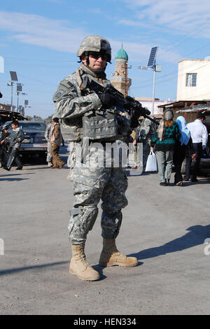 McAllister, Okla., native, Command Sgt. Maj. Jim Tomlinson, the senior non-commissioned officer for the 2nd Battalion, 319th Airborne Field Artillery Regiment, 2nd Brigade Combat Team, 82nd Airborne Division, provides security for his men during a patrol through a market area in the Rabi neighborhood of northeast Baghdad, Dec. 19. Sergeant Major's got you covered 70302 Stock Photo