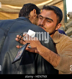 A liberate prisoner from an al-Qaida in Iraq torture chamber is reunited with his family Jan. 20 at Forward Operating Base Warhorse, Iraq, after 11 days of confinement and beatings. CF Liberate Two From Al-Qaida Prison-torture Chamber in Diyala 73608 Stock Photo