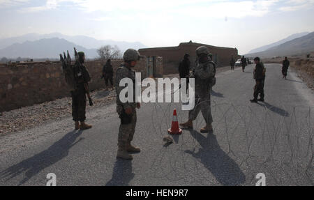 Staff Sgt. William Mcclain and Pfc. Jimmy Armenta from B Company, Division Special Troops Battalion, Task Force Gladius, Forward Operating Base Morales Frasier, set up the southern checkpoint at an Afghan police checkpoint on the main supply route, Tagab District, Kapisa province, Afghanistan, while Afghan soldiers patrol the MSR and pull security on Feb. 3, 2008. Activities in Kapisa Province 103266 Stock Photo