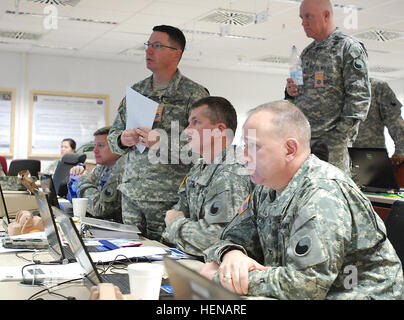 (Left to right) Maj. Chuck Reinhold, Lt. Col. David Jones, Brig. Gen. Timothy E. Gowen, Col. William Coffin and Col. Brent Johnson (standing) conduct a briefing Jan. 23, 2014 at the Joint Multinational Readiness Center in Hohenfels, Germany. Approximately 30 29th Infantry Division Soldiers from both the Maryland and Virginia National Guard are in Germany for a Kosovo Force mission rehearsal exercise. KFOR 14-02A, scheduled to run from Jan. 16-31, is designed to prepare 1,500 American and international troops to assume responsibility for Multinational Battle Group- East in Kosovo beginning in F Stock Photo