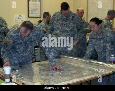 Lt. Col. Jimmy Kleager (left), 1st Stryker Brigade Combat Team, 25th Infantry Division plans and operations officer, Col. Brian Reed (center), 1/25 SBCT commander, and Maj. Kelly Markin, 1/25 SBCT intelligence officer, locate significant actions on a map during the Enhanced Leader Training Program at the National Training Center, Fort Irwin, Calif. More than 200 Soldiers from 1/25 SBCT are currently deployed to NTC to take part in the first ELTP, a program that provides training leaders training focused on the military decision making process. (Photo by Staff Sgt. Mylinda DuRousseau, 1/25 SBCT Stock Photo