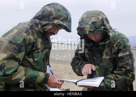 Two 201st Afghan National Army Corps soldiers use the notes and drawings they just made from investigating an artificial unexploded round to try and identify it while training at Forward Operating Base Gamberi, Feb. 6, 2014. Members of the 663rd Explosive Ordnance Disposal Company held the training for the Afghan soldiers to help get them ready to for the ANA's EOD school. (U.S. Army Photo by Spc. Eric Provost, Task Force Patriot PAO) Soldiers show Afghans ropes of explosive ordnance disposal 140206-A-CB167-004 Stock Photo