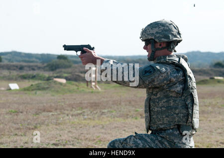 Spc. Adam Waldo, a psychological operations specialist with the 344th Psyop Company, fires an M9 pistol during that portion of the German Armed Forces Badge competition March 20, 2014, on Camp Bullis, San Antonio, Texas. The GAFB was a week long event where Soldiers endured rigorous testing in events ranging from CLS to swimming. (U.S. Army photo by Spc. Lalita Guenther) Firing line 140319-A-OD395-043 Stock Photo