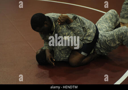 Pfc. Michael Gales (top), from Atlanta, Ga., a motor transport operator assigned to 579th Forward Support Company, 6th Battalion, 37th Field Artillery Battalion, 210th Field Artillery Brigade, tries for an arm-bar against his opponent during a training session March 31, 2014, at Carey Fitness Center on Camp Casey, South Korea. (U.S. Army photo by Sara E. Wiseman, 210th Field Artillery Brigade Public Affairs/Released) Soldier overcomes obstacles in pursuit of greatness 140331-A-DF794-031 Stock Photo