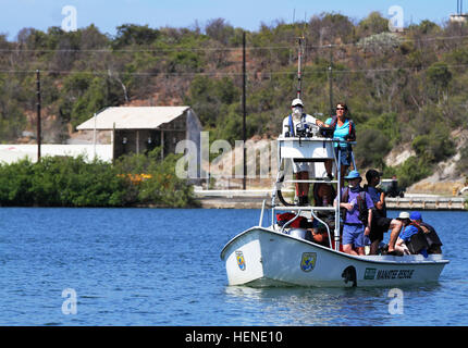 Jim Reid, Susan Butler, Dr. Judd Kenworthy and other volunteers on the main United States Geological Survey boat scan the waters Monday, for a manatee in one of the many canals of U.S. Naval Station Guantanamo Bay. Manatees, a highly instinctive and intelligent animal, has a long memory and often eludes researchers just beyond their reach. The USGS crew finally managed to bring in a manatee on Tuesday for tagging and an encompassing health assessment before being released back into the bay. (Photo by U.S. Army Sgt. Spencer Rhodes) The hunt for GTMO sea cow 140407-A-EG775-005 Stock Photo