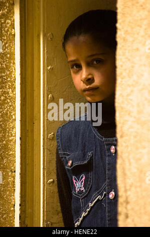 An Iraqi student peeks out from around the corner to catch a view of Soldiers from the 411th Military Police Company, 716th MP Battalion, 18th MP Brigade, Multi-National Division – Baghdad as they stand guard outside her elementary school in the village of Abayachi, north of Baghdad, March 2. Soldiers from the 411th MP Co. supported the mission of Company B, 1st Battalion, 14th Infantry Regiment, 2nd Stryker Brigade Combat Team, “Warrior,” 25th Infantry Division, MND-B to pay local Sons of Iraq (Abna al Iraq) volunteers from the Abayachi area. Soldiers support payday activities 79516 Stock Photo