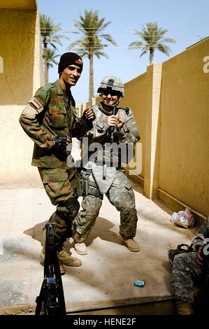 Pfc. Kayla Deboard, an Ocala, Fla., native, who serves as a military police officer for the 411th Military Police Company, 716th MP Battalion, 18th MP Brigade, Multi-National Division – Baghdad takes a moment to relax and dance to some tunes with an Iraqi Soldier at an elementary school in the village of Abayachi, north of Baghdad, March 2. Soldiers from the 411th MP Co. supported the mission of Company B, 1st Battalion, 14th Infantry Regiment, 2nd Stryker Brigade Combat Team, “Warrior,” 25th Infantry Division, MND-B to pay local Sons of Iraq (Abna al Iraq) volunteers Abayachi area. Soldiers s Stock Photo