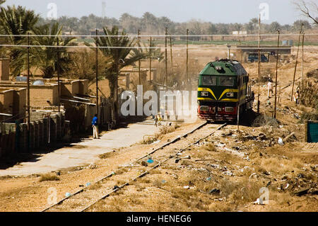 An Iraqi locomotive passes a crowd of villagers upon its approach to the rail road gate to Camp Taji, Iraq Mar. 5 marking the first time a train as arrived at the installation since the beginning of Operation Iraqi Freedom. Multi-National Division – Baghdad Soldiers from the 2nd Battalion, 11th Field Artillery Regiment, 2nd Stryker Brigade Combat Team, 25th Infantry Division, MND-B provided force protection measures required for the vehicle to gain access to the coalition base. Taji rail lines open for first time since start of war 79310 Stock Photo