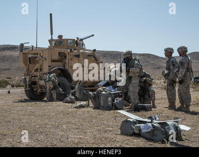 FORT IRWIN, Calif. - U.S. Army Soldiers, assigned to 977th Military Police Company, 97th Military Police Battalion, 1st Infantry Division, conduct communication checks on an AeroVironment RQ-11 Raven prior to launch during a training operation at the National Training Center, April 19, 2014. The Raven is a small hand-launched remote- controlled unmanned aerial vehicle (UAV) used to show higher command a birds eye view of a specific terrain.  (U.S. Army photo by Sgt. Richard W. Jones Jr., Operations Group, National Training Center) Communication checks 140419-A-QU939-411 Stock Photo