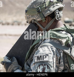 FORT IRWIN, Calif. - A U.S. Army Soldier, assigned to 977th Military Police Company, 97th Military Police Battalion, 1st Infantry Division, controls the flight of an AeroVironment RQ-11 Raven during a training operation at the National Training Center, April 19, 2014. The Raven is a small hand-launched remote- controlled unmanned aerial vehicle (UAV) used to show higher command a birds eye view of a specific terrain.  (U.S. Army photo by Sgt. Richard W. Jones Jr., Operations Group, National Training Center) Raven training operation 140419-A-QU939-734 Stock Photo