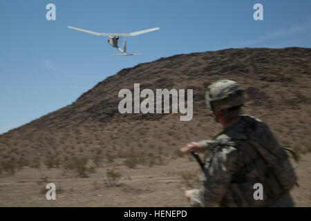 A U.S. Army Soldier, assigned to 977th Military Police Company, 97th Military Police Battalion, 1st Infantry Division, throws an AeroVironment RQ-11 Raven during a training operation at the National Training Center, April 19, 2014. The Raven is a small hand-launched remote- controlled unmanned aerial vehicle (UAV) used to show higher command a bird's eye view of a specific terrain.  (U.S. Army photo by Sgt. Richard W. Jones Jr., Operations Group, National Training Center) National Training Center RQ-11 Raven exercise 140419-A-QU939-271 Stock Photo