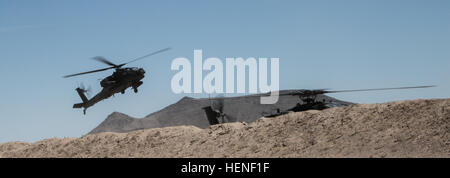 U.S. Army Soldiers, assigned to 1st Battalion, 25th Aviation Regiment, 25th Infantry Division, land an AH-6E Apache Guardian at Forward Operating Base Seattle during Decisive Action Rotation 14-06 at the National Training Center on Fort Irwin, Calif., April 24, 2014. The new aircraft features an updated cockpit, and new fire control system.  (U.S. Army photo by Sgt. Richard W. Jones Jr./Released) AH-6E Apache Guardian training 140424-A-QU939-013 Stock Photo