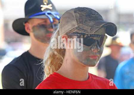 One of nearly 30 spouses from 3rd Squadron, 1st Cavalry Regiment, 3rd Armored Brigade Combat Team, 3rd Infantry Division, listens intently during a CBRN-E lane, April 26, at Sledgehammer Field. The women formed up and marched to various lanes throughout Kelley Hill, where they had to fire weapons at the Engagement Skills Trainer, don a pro-mask during a chemical attack, provide aid to a casualty while preparing him for a medical evacuation, react to contact while calling for fire, and answer cavalry-related questions during a Spur Board. Blackhawk spouses earn spurs 140426-A-IP604-549 Stock Photo