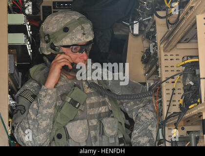 A 2nd Heavy Brigade Combat Team Soldier uses a radio from inside a Mine Resistant Ambush Protected vehicle equipped with multiple communication platforms during the Network Integration Evaluation 14.2 here May 1. This is the first NIE to test joint and multinational interoperability thanks to the participation of a U.S. Marine Corps Infantry Battalion and United Kingdom mechanized brigade headquarters, better simulating the complexities of the operational environment such a tactical network will be operating under. (U.S. Army photo by Staff Sgt. Richard Andrade, 16th Mobile Public Affairs Deta Stock Photo