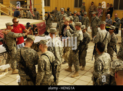 U.S. Army Soldiers assigned to 5th Battalion, 25th Field Artillery Regiment, 4th Brigade, 10th Mountain Division, enjoy a visit from former professional wrestler Diamond Dallas Page, actress Cynthia Watros and television personality Bonnie-Jill Laflin, as part of the Ambassadors of Hollywood Tour, sponsored by Morale Welfare and Recreation at Forward Operating Base Rustamiyah, Baghdad, Iraq, March 13, 2008. (U.S. Air Force photo by Staff Sgt. Jason T. Bailey)(Released) Page Watros Laflin Stock Photo