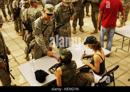 U.S. Army Soldiers assigned to 5th Battalion, 25th Field Artillery Regiment, 4th Brigade, 10th Mountain Division, enjoy a visit from former professional wrestler Diamond Dallas Page, actress Cynthia Watros and television personality Bonnie-Jill Laflin, as part of the Ambassadors of Hollywood Tour, sponsored by Morale Welfare and Recreation at Forward Operating Base Rustamiyah, Baghdad, Iraq, March 13, 2008. (U.S. Air Force photo by Staff Sgt. Jason T. Bailey)(Released) Laflin Watros Iraq Stock Photo