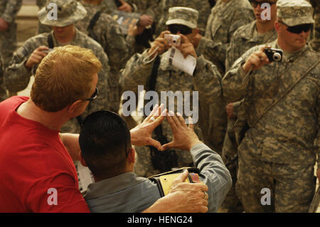 U.S. Army Soldiers assigned to 5th Battalion, 25th Field Artillery Regiment, 4th Brigade, 10th Mountain Division, enjoy a visit and pictures with former professional wrestler Diamond Dallas Page, actress Cynthia Watros and television personality Bonnie-Jill Laflin, as part of the Ambassadors of Hollywood Tour, sponsored by Morale Welfare and Recreation at Forward Operating Base Rustamiyah, Baghdad, Iraq, March 13, 2008. (U.S. Air Force photo by Staff Sgt. Jason T. Bailey)(Released) Diamond Dallas Page Iraq Stock Photo