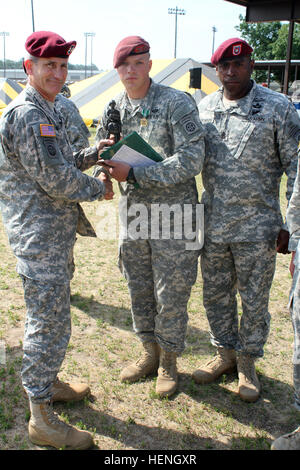 Maj. Gen. John W. Nicholson Jr., commander of the 82nd Airborne Division, and Command Sgt. Maj. LaMarquis Knowles, command sergeant major of the 82nd Airborne Division, present a trophy to Sgt. Christopher Lord from 2nd Battalion, 319th Airborne Infantry Regiment, 2nd Brigade Combat Team, 82nd Airborne Division, for winning the 2014 82nd Airborne Division's Noncommissioned Officer of the Year competition. The division's NCO of the Year competition determines the best noncommissioned officer in the division. In a glass case in the 82nd Airborne Division headquarters are the names of 28 division Stock Photo