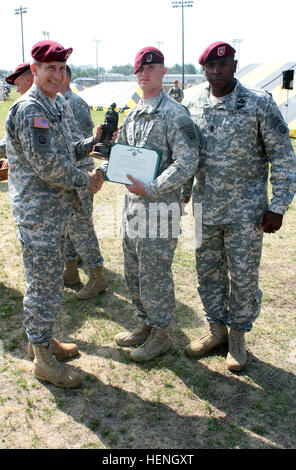 Maj. Gen. John W. Nicholson Jr., commander of the 82nd Airborne Division, and Command Sgt. Maj. LaMarquis Knowles, command sergeant major of the 82nd Airborne Division, present a trophy to Spc. Daulton Moore from 1st Squadron, 73rd Cavalry Regiment, 2nd Brigade Combat Team, 82nd Airborne Division, for winning the 2014 82nd Airborne Division's Trooper of the Year competition. The division's Trooper of the Year competition determined the best trooper in the division. A glass case in the 82nd Airborne Division headquarters showcases the names of 57 division Paratroopers of the Year, etched on gol Stock Photo
